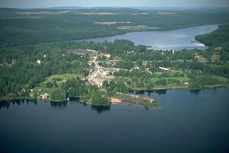 Flygbild över Långbans gruvby med gruvfält, bebyggelse, skog och omgivande sjöar.
